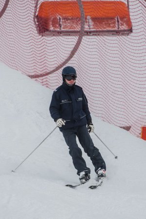 Kręcie mnie bezpieczeństwo na stoku - Kasina - policjant na stoku na nartach, w tle siatka zabezpieczająca