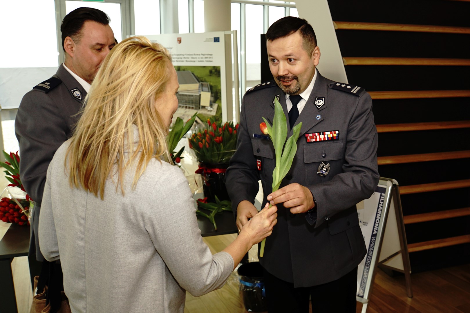 Komendant Wojewódzki Policji w Olsztynie wręcza kwiaty z okazji Dnia Kobiet