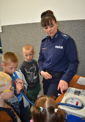 dzieci zwiedzają komendę policji w towarzystwie policjantki