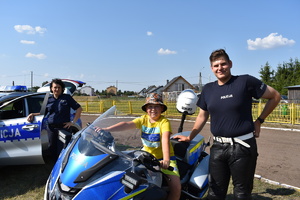 dziecko na policyjnym motocyklu, obok policjant