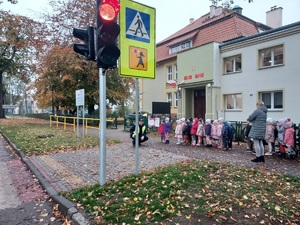 spotkanie dzielnicowego z przedszkolakami z Sępopola, policjant przy przejściu dla pieszych z grupą dzieci