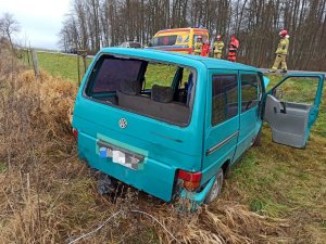 niebieski bus VW w przydrożnym rowie, uszkodzony po zdarzeniu drogowym