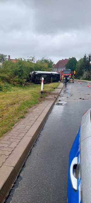 miejsce zdarzenia drogowego na K57 w Bisztynku, służby ratownicze pracują na miejscu zdarzenia, na poboczu przewrócona na bok ciężarówka