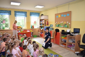 spotkanie z dziećmi w PP nr 2 w Bartoszycach, policjantka z dziećmi czyta napis Policja na jej koszulce