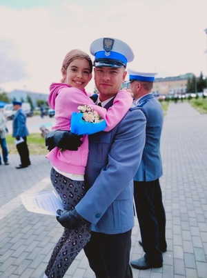 Policjant z dzieckiem na rękach