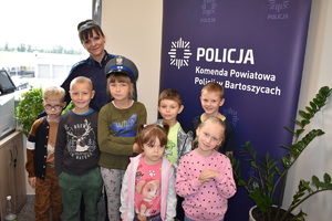 dzieci zwiedzają komendę policji w towarzystwie policjantki