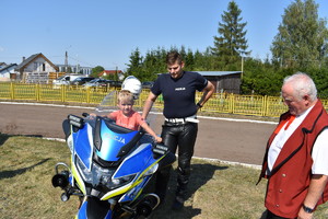 dziecko na policyjnym motocyklu, obok policjant